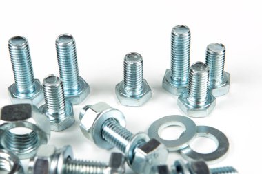 Metal cıvatalar ve fındıklar. Yuvarlak temizleyiciler beyaz arka planda.