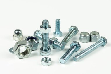 Metal cıvatalar ve fındıklar. Yuvarlak temizleyiciler beyaz arka planda.