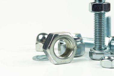 Metal cıvatalar ve fındıklar. Yuvarlak temizleyiciler beyaz arka planda.