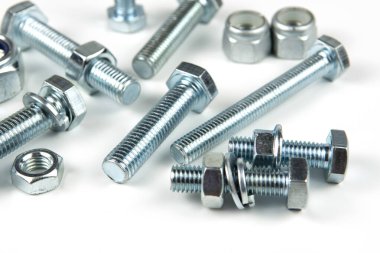 Metal cıvatalar ve fındıklar. Yuvarlak temizleyiciler beyaz arka planda.