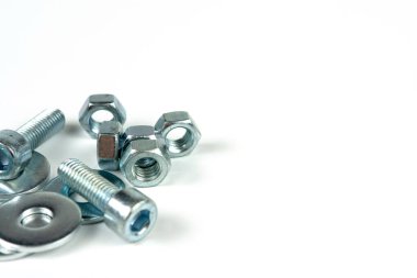 Metal cıvatalar ve fındıklar. Beyaz arka planda yuvarlak temizleyiciler var. Boşluğu kopyala