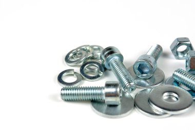 Metal cıvatalar ve fındıklar. Beyaz arka planda yuvarlak temizleyiciler var. Boşluğu kopyala