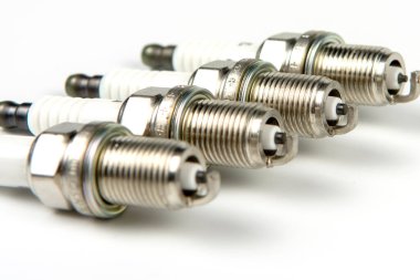 Araba servisi. Motorlu taşıtların yedek parçası olarak yeni bir buji seti. Motorun yakın çekimi için mum grubu