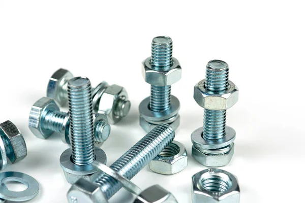 Metal cıvatalar ve fındıklar. Yuvarlak temizleyiciler beyaz arka planda.