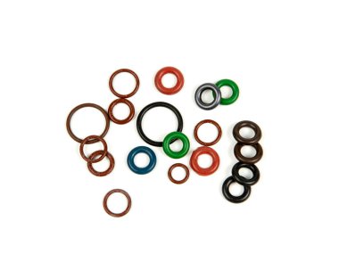 Hidrolik ve pnömatik o-halkalar farklı boyutlarda ve renklerde, beyaz bir arka planda. Tesisat için çeşitli mühürler. Hidrolik bağlantılar için halkalar mühürleniyor.