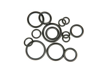 Hidrolik ve pnömatik o-halkalar beyaz arka planda farklı boyutlarda siyah renkte. Tesisat için çeşitli mühürler. Hidrolik bağlantılar için halkalar mühürleniyor.