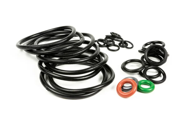 Hidrolik ve pnömatik o-halkalar farklı boyutlarda ve renklerde, beyaz bir arka planda. Tesisat için çeşitli mühürler. Hidrolik bağlantılar için halkalar mühürleniyor.