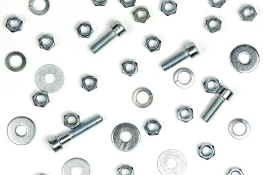 Beyaz arka planda fındıklı birkaç gümüş metal cıvata. soyut arkaplan, yakın plan
