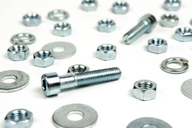 Beyaz arka planda fındıklı birkaç gümüş metal cıvata. soyut arkaplan, yakın plan