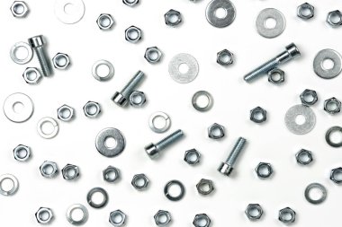 Beyaz arka planda fındıklı birkaç gümüş metal cıvata. soyut arkaplan, yakın plan