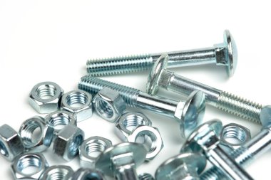 Beyaz arka planda fındıklı birkaç gümüş metal cıvata. Boşluğu kapat ve kopyala
