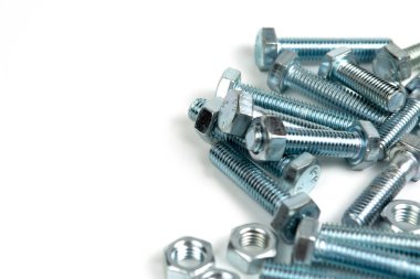 Beyaz arka planda fındıklı birkaç gümüş metal cıvata. Boşluğu kapat ve kopyala