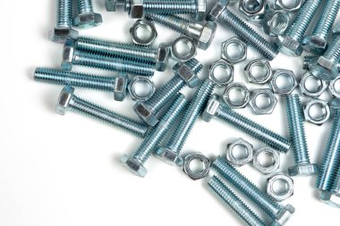 Beyaz arka planda fındıklı birkaç gümüş metal cıvata. Boşluğu kapat ve kopyala