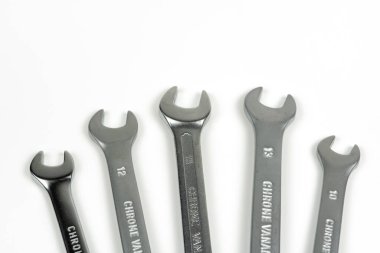 Beyaz arka planda cıvata ve fındıkları sıkmak için bir grup yeni metal anahtar.