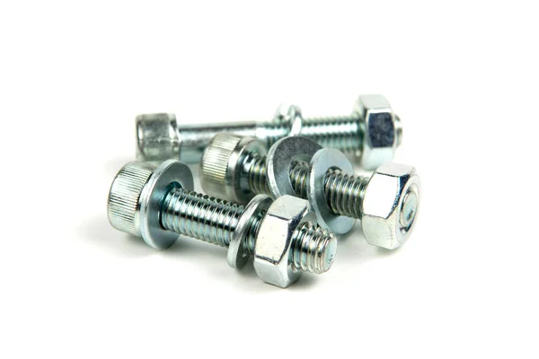 Beyaz arka planda birkaç metal yıkama, fındık ve gümüş renkli cıvata var. yakın plan