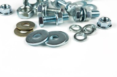 Metal cıvatalar ve fındıklar. Beyaz arka planda yuvarlak temizleyiciler var. Boşluğu kopyala