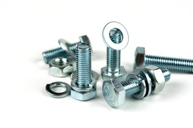 Metal cıvatalar ve fındıklar. Yuvarlak temizleyiciler beyaz arka planda.