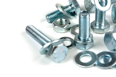 Metal cıvatalar ve fındıklar. Beyaz arka planda yuvarlak temizleyiciler var. Boşluğu kopyala