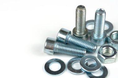 Metal cıvatalar ve fındıklar. Beyaz arka planda yuvarlak temizleyiciler var. Boşluğu kopyala