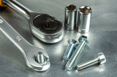 İngiliz anahtarı, metal bir fındığı çelik bir iş parçasına sıkıştırır. Kafalar ve cırcır. Yakın plan..