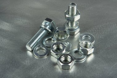 Bağlantıları birleştirmek için Fasteners. Fındık ve cıvatalar. Metal bir boşluğun arka planına yakın plan.
