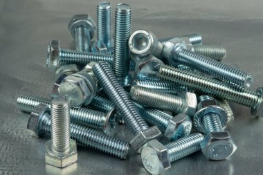 Bağlantıları birleştirmek için Fasteners. Fındık ve cıvatalar. Metal bir boşluğun arka planına yakın plan.