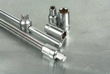 Gri metal bir masada oto tamircisi aletleri. Gri arkaplanda yakın plan