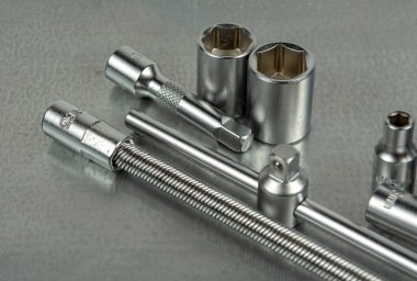 Gri metal bir masada oto tamircisi aletleri. Gri arkaplanda yakın plan