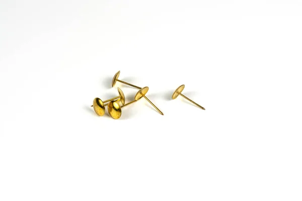 Beyaz arka planda altın raptiyeler, yakın plan, yakın çekim. Kırtasiye malzemeleri. Belgelerle çalışmak için ekipman.