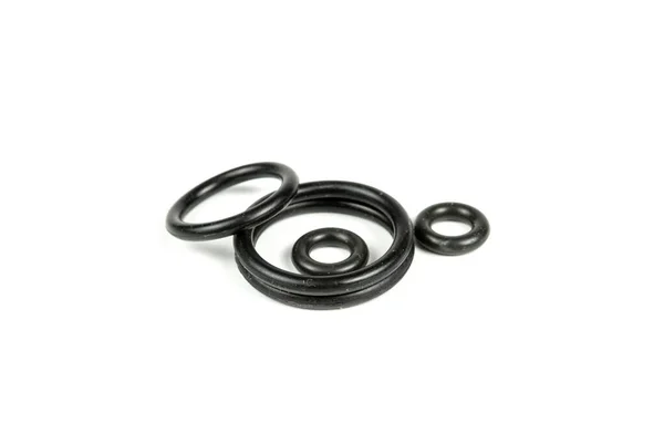 Hidrolik ve pnömatik o-halkalar beyaz arka planda farklı boyutlarda siyah renkte. Tesisat için çeşitli mühürler. Hidrolik bağlantılar için halkalar mühürleniyor.