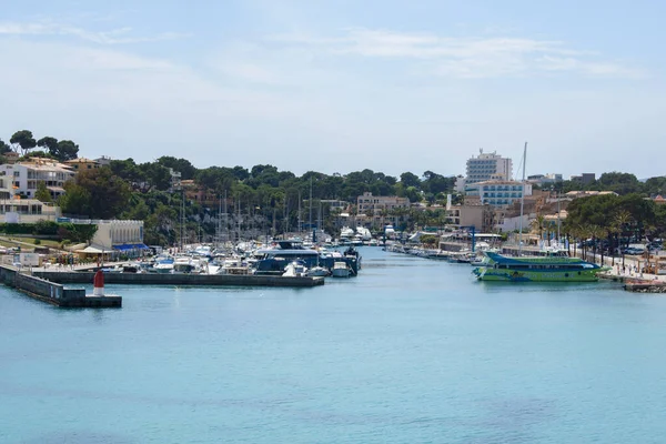 Porto Cristo, Mallorca, İspanya - 05.02.2022: Porto Cristo limanında yatlar ve tekneler. Arka planda kayalıklardaki evler