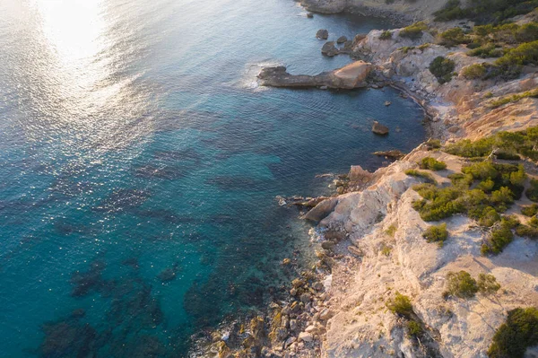 Kayaların yüksek açılı havası ve durgun turkuaz deniz suyu.