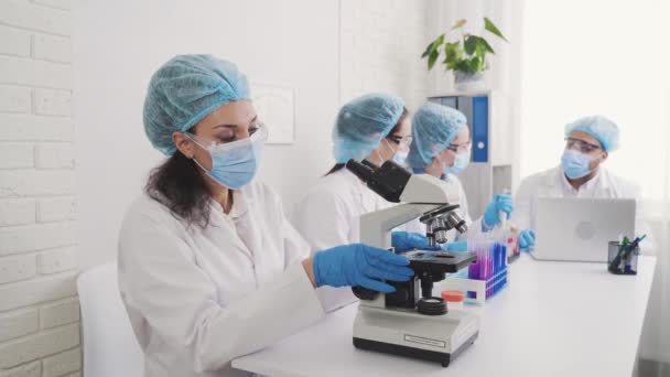 Medical Development Laboratory: Kijken onder de microscoop, analyseert monster — Stockvideo