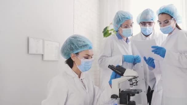 Лабораторія медичного розвитку: пошук під мікроскопом, аналіз вибірки — стокове відео
