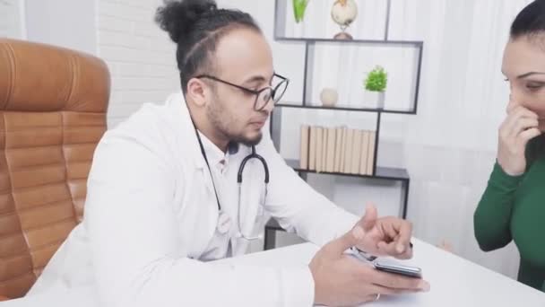 Africký americký lékař ukazuje obrazovku pacientů smartphone — Stock video