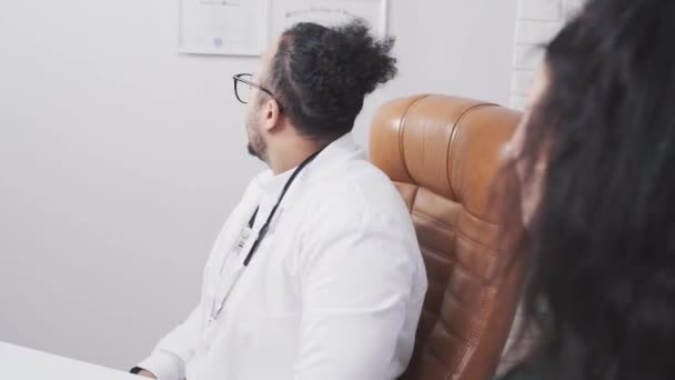 Africký americký lékař v lékařské ordinaci se dívá na diplomy — Stock video