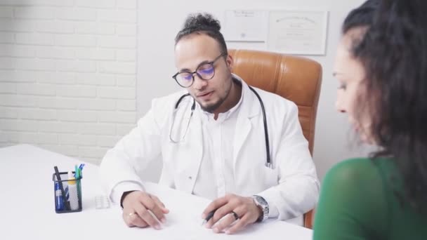 Africký americký lékař podepíše dokument s pacientem — Stock video