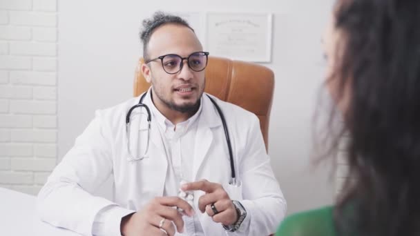 Άντρας γιατρός στο ιατρικό γραφείο κρατώντας χάπια στο χέρι του — Αρχείο Βίντεο