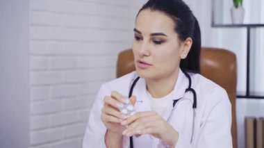 Tıbbi toplantı, doktor kadın yakın plan meslektaşlarına hapların bileşiminden bahsediyor