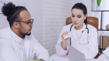 Tıbbi toplantı, doktor kadın iğne meslektaşlarına hapların bileşiminden bahsediyor