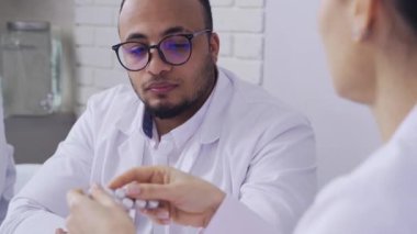 Tıbbi toplantı, doktor kadın yakın plan meslektaşlarına hapların bileşiminden bahsediyor