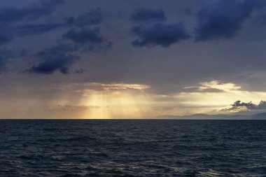 Batan güneş, Karadeniz 'in üzerindeki bulutların arasından parlıyor..