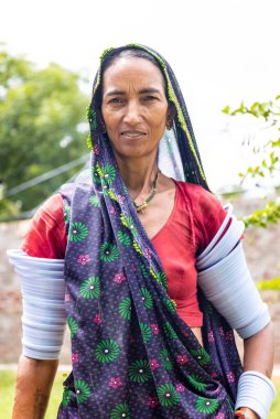 Jawai, Rajasthan, India - September 2021: Portrait of Indian woman working at construction site in ethnic rajasthani dress. Indian labour at working site.