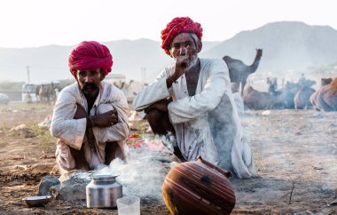 Puşkar, Rajasthan / Hindistan - Kasım 2019: Rajasthan halkı fuar alanında grup halinde chilam içiyor 