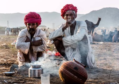 Puşkar, Rajasthan / Hindistan - Kasım 2019: Rajasthan halkı fuar alanında grup halinde chilam içiyor 