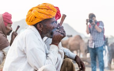 Puşkar, Rajasthan, Hindistan - Kasım 2019: Rajasthan 'lı Hintli erkekler fuar sırasında açık arazide sigara içiyorlar
