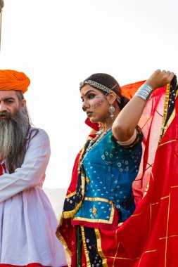 Puşkar, Rajasthan, Hindistan - Ekim 2019: Geleneksel Rajasthani ailesinin portre çekimi ve Pushkar Deve Fuarı 'nın arka planında develer