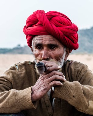 Puşkar, Rajasthan, Hindistan Ekim 2017: Kafasında Puro ve Kızıl Türbanlı Rajasthani Yaşlısı 