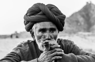 Puşkar, Rajasthan, Hindistan Ekim 2017: Kafasında Puro ve Kızıl Türbanlı Rajasthani Yaşlısı 