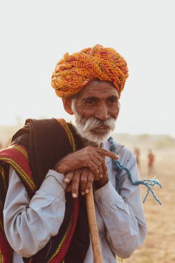 PUSHKAR, RAJASTHAN / INDIA - Kasım 2019: Pushkar deve panayırında geleneksel elbise ve türban giymiş Rajasthani erkeğinin portresi